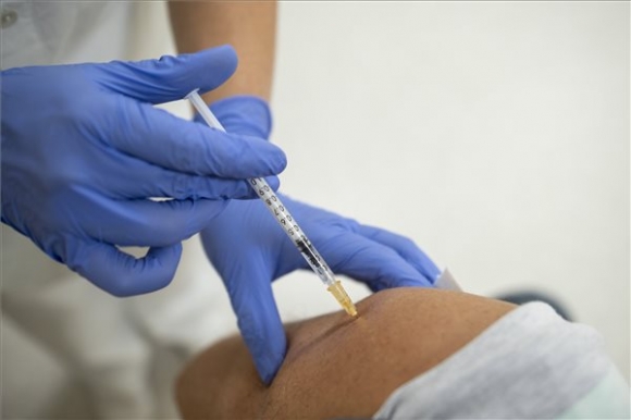 Beoltanak egy férfit a német-amerikai fejlesztésű Pfizer-BioNTech koronavírus elleni oltóanyag, a Comirnaty-vakcina harmadik, emlékeztető adagjával a gyöngyösi Bugát Pál Kórház oltópontján 2021. október 1-jén (MTI/Komka Péter)