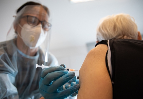 Egészségügyi dolgozó egy lakót olt be a Pfizer-BioNTech koronavírus elleni vakcinájának első adagjával a fővárosi Kálvin János Református Idősek Otthonában. Fotó: MTI/Mohai Balázs